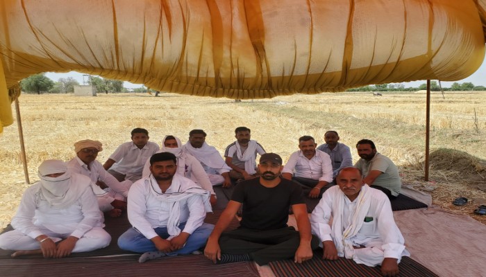खेतों से होकर बिजली की तारें खींचे जाने से किसान नाराज, भीषण गर्मी में कर रहे प्रदर्शन